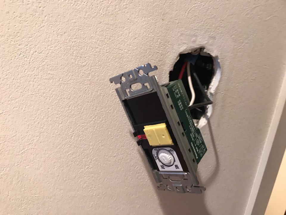 新しいスイッチに配線をつなぎ壁に取り付ける